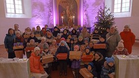 Die beschenkten Familien versammelten in der Ev. Kirche in Matiši zusammen mit der Leiterin der Sonntagsschule Kristine Daiga (vorne links), Kirchenvorstand Sandra Kruzkope und Pastor Raitis Jakobsons (beide hinten links). 		Foto: privat
