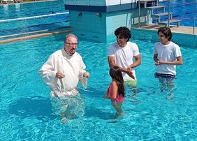 Pfarrer Marco Beuermann (links) taufte Sara, Sam und Hami in einem Becken des Rhedaer Freibads. Foto: privat